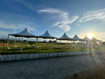 Hexagonal Tents Along the Riverside Lawn